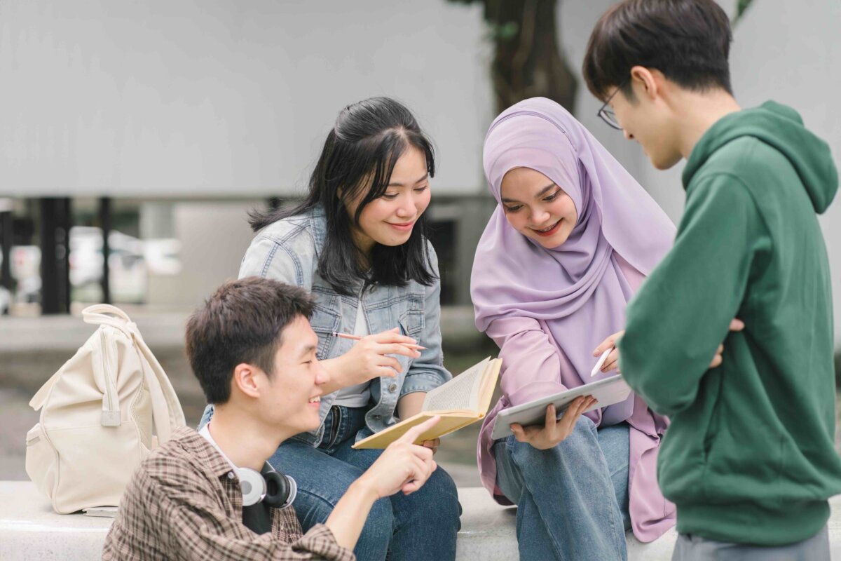 Asian diverse group of university students working together outdoors on campus